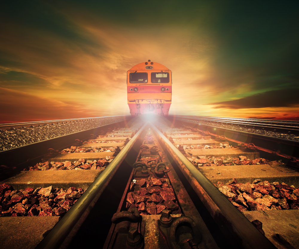 trains on junction of railways track in trains station agains beautiful light of sun set sky use for land transport and logistic industry background ,backdrop,copy space theme